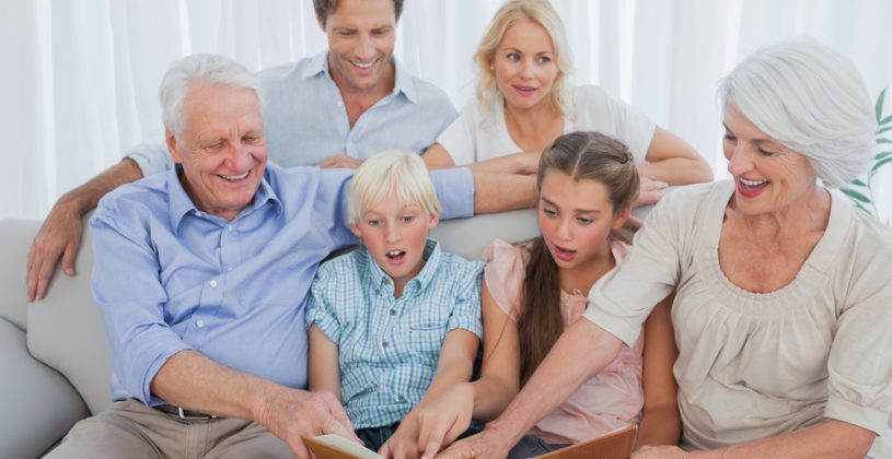 Three generations of family looking at a photo album. Family memories are a precious part of a family’s legacy and they deserve to be carefully preserved