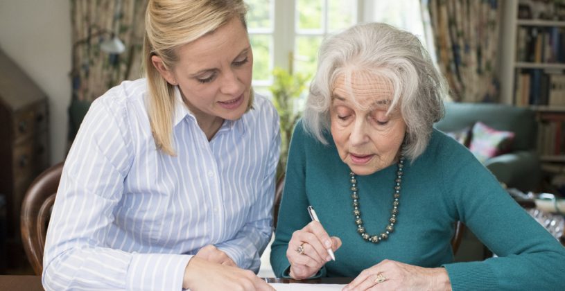 senior woman and daughter looing at paperwork together