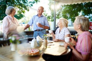 Senior man and women enjoying an outdoor snack and a laugh. Natural light provides a number of benefits from boosting Vitamin D levels to improving mood.