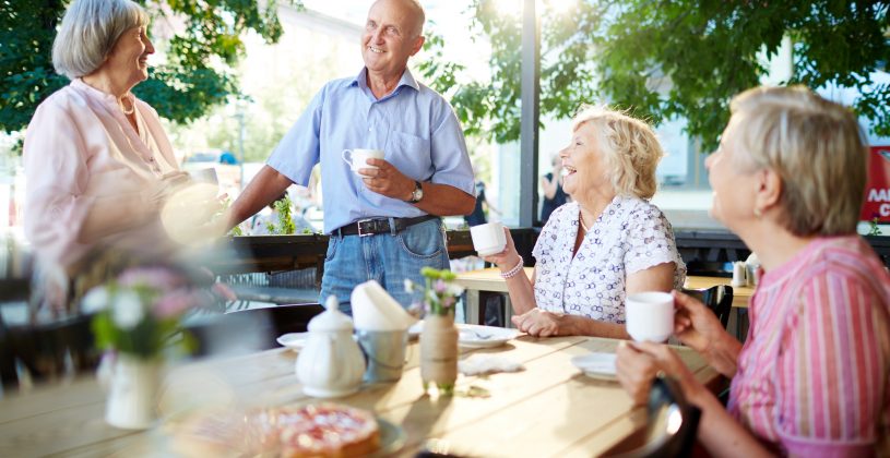 Senior man and women enjoying an outdoor snack and a laugh. Natural light provides a number of benefits from boosting Vitamin D levels to improving mood.
