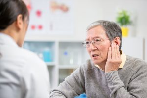 Senior seeing an auditory specialist for assistance with a hearing impairment.