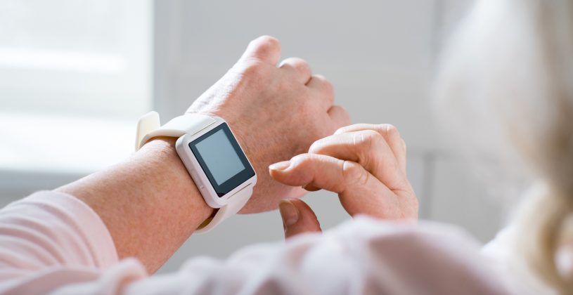 Senior looks at her smartwatch. Wearable technology devices offer several benefits to seniors.