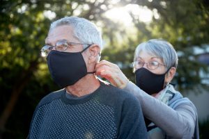 Active senior couple wearing snug fitting masks as a precaution against COVID-19.