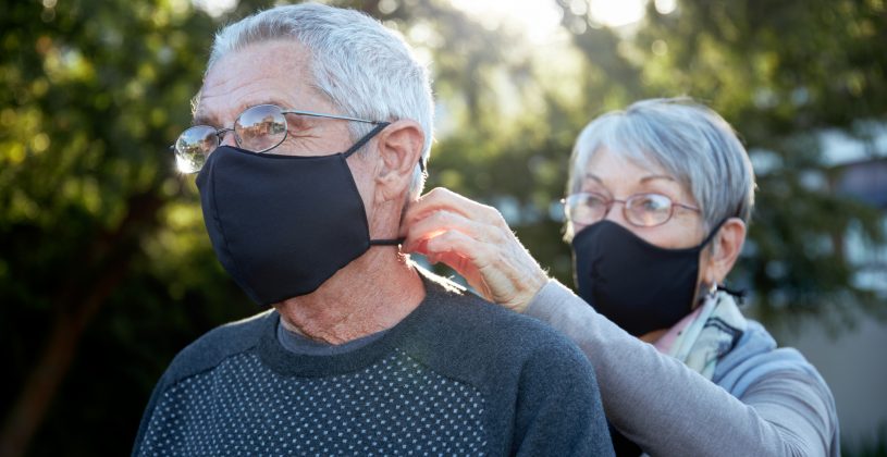 Active senior couple wearing snug fitting masks as a precaution against COVID-19.