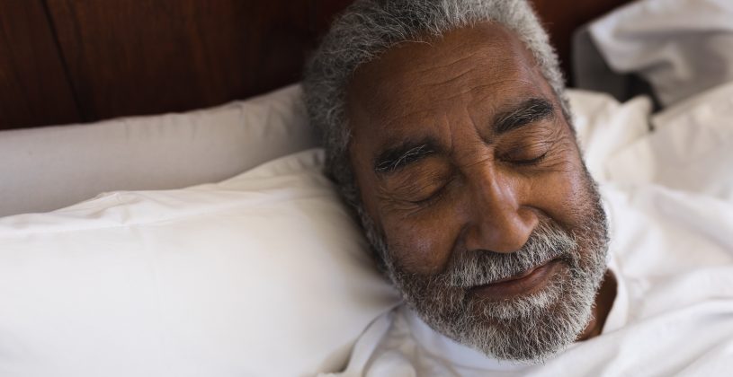 African American man sleeping peacefully on a pillow.