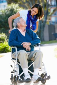 Caregiver pushing senior man in wheelchair