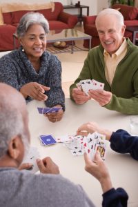 Image of a group of seniors playing a card game. 