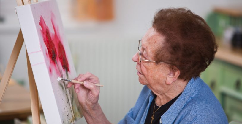 senior woman painting on a canvas